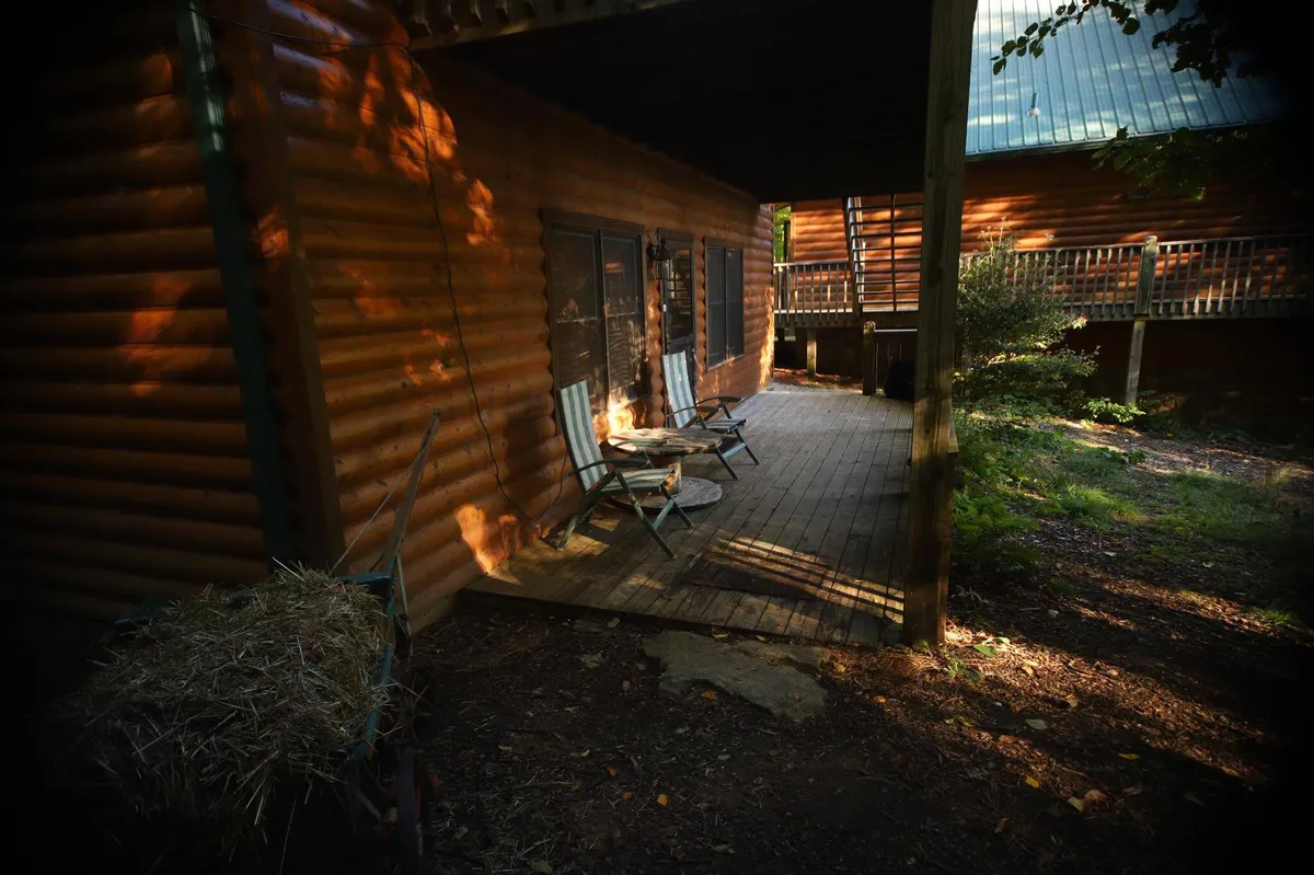 This image features a wooden deck with two chairs overlooking natural surroundings, exuding tranquility and a direct connection to the outdoors. The deck is set up for quiet relaxation, with open views that invite guests to savor the mountain air and scenery.