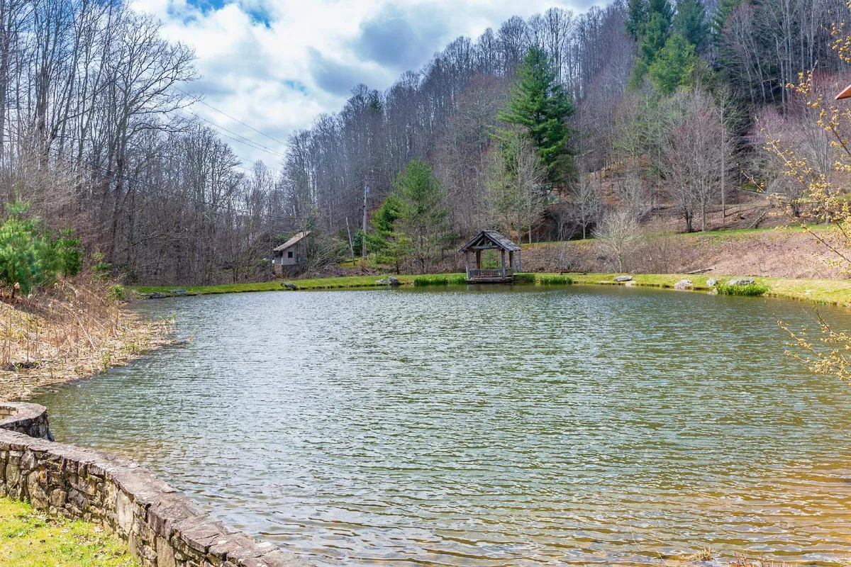 A peaceful fishing pond with a charming gazebo nestled among surrounding trees. The serene waters reflect the beauty of the natural landscape, inviting guests to relax, fish, picnic, or simply enjoy the view.